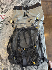 Black mesh backpack on a marble surface with a wooden floor background
